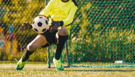 Young Goalkeeper Making a Save. Kids Soccer Training, Youth Football Match, Goalkeeping Skills, Junior Sports, Outdoor Football Actionの写真素材