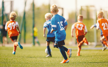 Kids Soccer Match Outdoors. Youth Football Game and Team Play on Grass Field during Training Sessionの写真素材