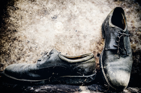 still life with boots on wooden table over grunge backgroundの写真素材