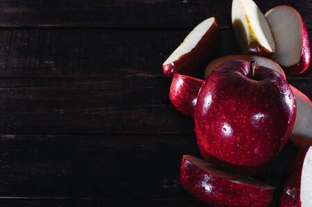 sliced apple and a whole apple on a wooden boardの写真素材