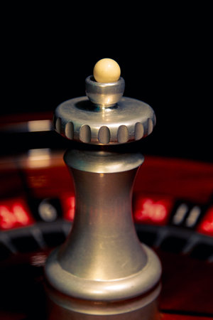A detailed close-up of the roulette wheel spindle captures the mechanical center of the game, emphasizing the precision, tension and anticipation associated with casino gambling.の写真素材