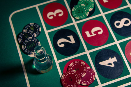 Stacks of poker chips placed on a roulette table illustrate the atmosphere of casino gaming, where...