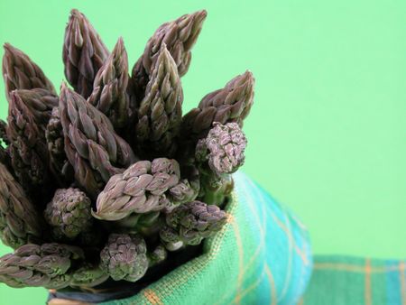 bunch of fresh green asparagus on green background - close-upsの写真素材