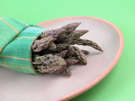 plate of fresh green asparagus on green background - close-upsの写真素材