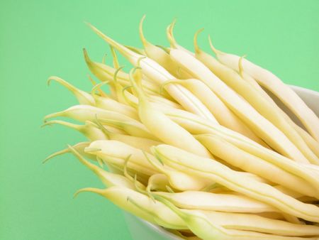 close-ups of yellow string beans - green background