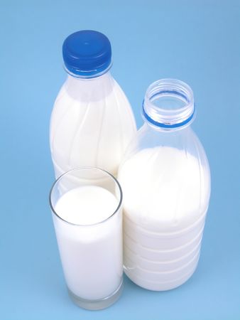 two bottles and glass of milk on blueの写真素材