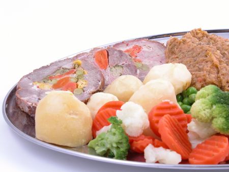 plate full of cooked vegetables and meatの写真素材