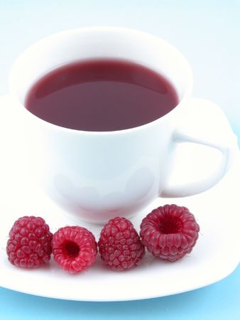 cup of tea with raspberry syrup and some fresh raspberries