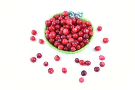 bowl full of fresh cranberries isolated on whiteの写真素材