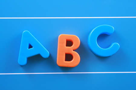 colorful letters A B C on blue board close-upsの写真素材