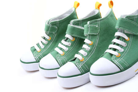 two pairs of green sneakers for children isolated on whiteの写真素材