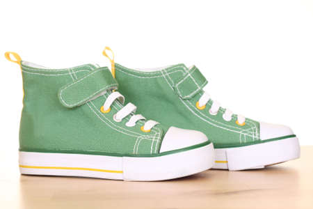 pair of green sneakers for children on the floorの写真素材