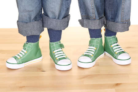 four children legs in sneakers on the floorの写真素材