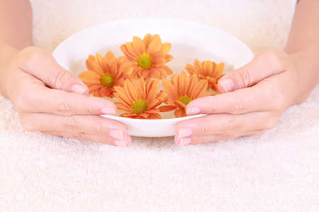 bowl of pure water and spring flowers - hands careの写真素材