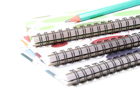 three spiral books and pencil isolated on whiteの写真素材
