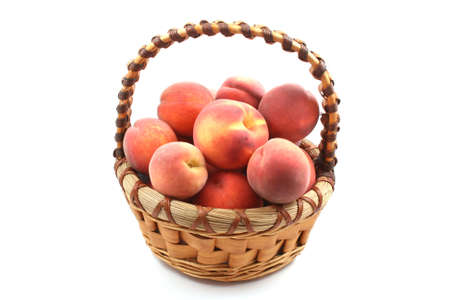 basket full of fresh peaches isolated on whiteの写真素材