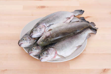 plate full of rainbow trouts on tableの写真素材