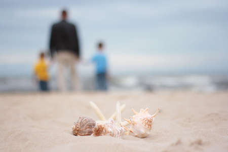 two boys and father on the beach - summertimeの写真素材