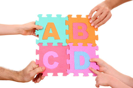hands holding puzzle with ABCD letters isolated on white