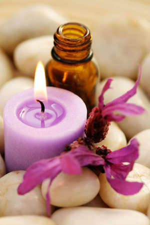 massage oil candle and lavender flowers in stones - relaxing time