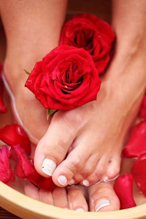 sexy female feet with bowl of water and roses - beauty treatmentの写真素材