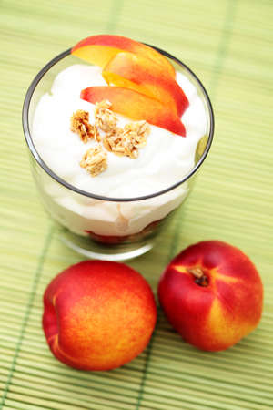 glass of yogurt with muesli and fresh nectarine - diet and breakfastの写真素材