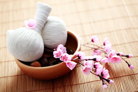 two massage stamps with bowl of stones - beauty treatmentの写真素材