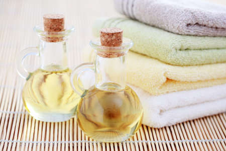 bottles of massage oil with towels - beauty treatmentの写真素材