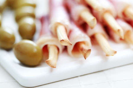 grissini with ham and olives as a snack - food and drinkの写真素材