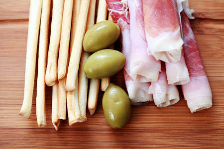 grissini with ham and olives as a snack - food and drinkの写真素材