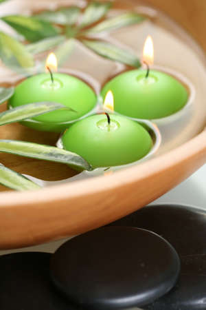 bowl of water with candles and pebblesの写真素材
