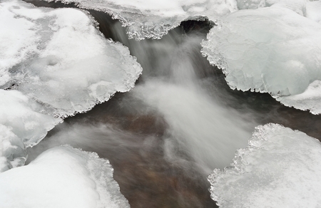 Water and ice in winter mountain streamの写真素材