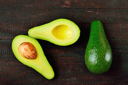 Fresh avocado isolated on wood table background. Tasty and vegetable health. Exotic fruit.