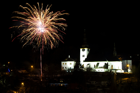 New Year`s Eve firework behind Christmas tree. Celebrating 2017 in Spania Dolina, Slovakia. Multicolor explosion on dark sky. Foundation day of Slovak republicのeditorial素材