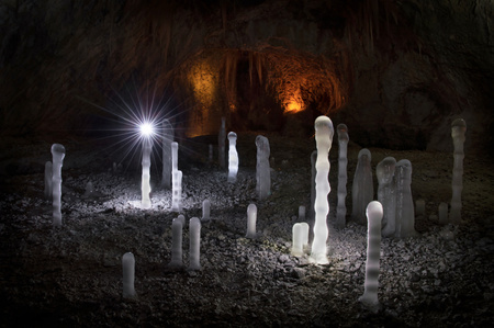 Winter icicles iluminated with battery and candles. Frozen cave in Slovakia. Stalactite and stalagmite. Exploration depths of the earth.の写真素材