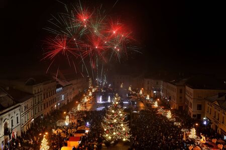 BANSKA BYSTRICA, SLOVAKIA - JANUARY 1, 2018: New Year`s Eve firework behind Christmas tree....