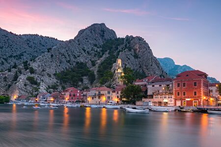 OMIS, CROATIA - AUGUST 8, 2018 City of Omis, Dalmatia, Croatia. Blue hour landscape view in historical city centre of Omis and Cetina river. Popular holiday destination in Croatiaのeditorial素材