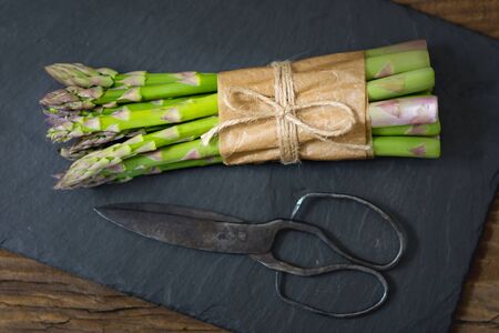 Bunch of raw asparagus on wooden table. Green fresh harvested vegetable. Healthy meal. Vegetarian and vegan food.の写真素材