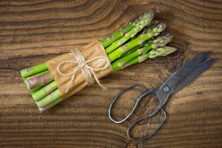 Bunch of raw asparagus on wooden table. Green fresh harvested vegetable. Healthy meal. Vegetarian and vegan food.の写真素材