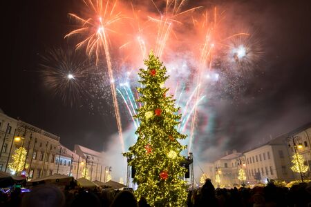 BANSKA BYSTRICA, SLOVAKIA - JANUARY 1, 2019: New Year`s Eve firework behind Christmas tree. Celebrating 2019 in Banska Bystrica, Slovakia. Multicolor explosion on dark sky. Foundation day of Slovak republicのeditorial素材