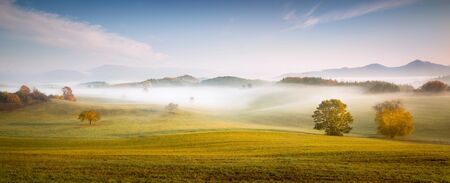 Fall in Slovakia. Meadows and fields landscape near Poniky. Autumn colored trees at sunrise