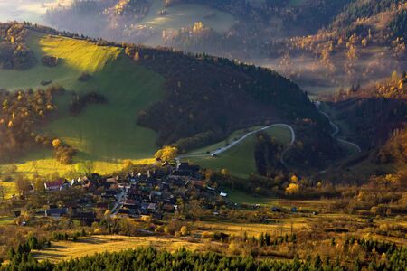 Fall in Slovakia. Meadows and fields landscape near Unesco monument reservation Vlkolinec at sunrise. Autumn colored trees.の写真素材
