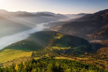Fall in Slovakia. Meadows and fields landscape near Unesco monument reservation Vlkolinec at sunrise. Autumn colored trees.の写真素材