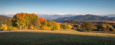 Fall in Slovakia. Meadows and fields landscape near Povraznik. Autumn colored trees at sunriseの写真素材