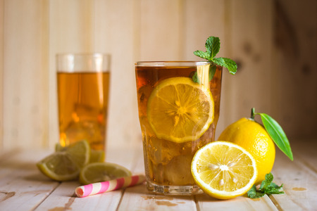 Glasses of ice tea with lemon slices  on wooden backgroundの写真素材