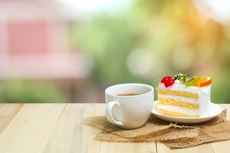 Slice cake with coffee cup on wood , green blur backgroundの写真素材
