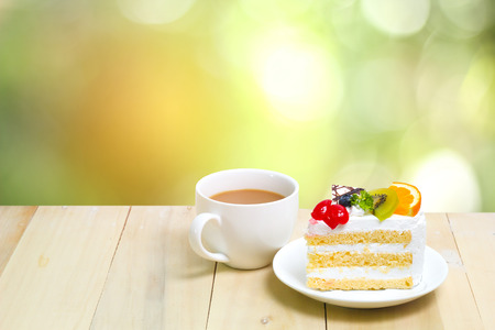Slice cake with coffee cup on wood , green blur backgroundの写真素材