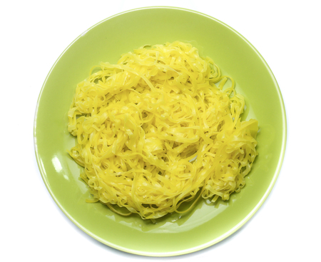 yellow noodles on dish isolated on white backgroundの写真素材