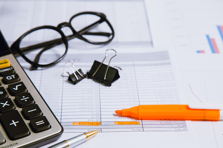 Spreadsheet bank accounts accounting with calculator and magnifying glass. Concept for financial fraud investigation, audit and analysis.の写真素材