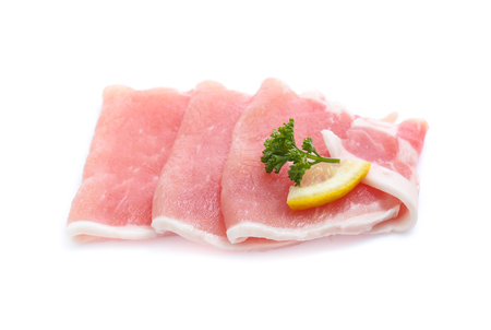 Raw pork meat with parsley herb leaves isolated on white backgroundの写真素材